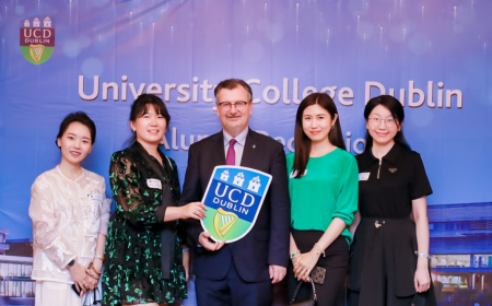 Professor Colin Scott posing for a photo with four alumnae.